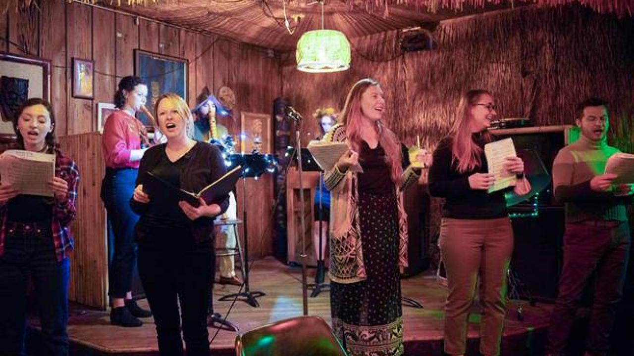 Group of singers on a dimly-lit stage