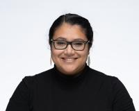 Melissa is smiling at the camera with a black turtle neck.